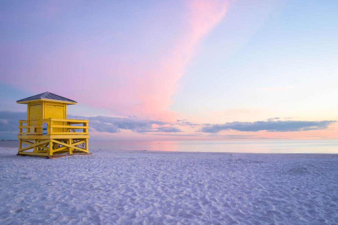 White sand beach and a yellow lifeguard hut at sunrise